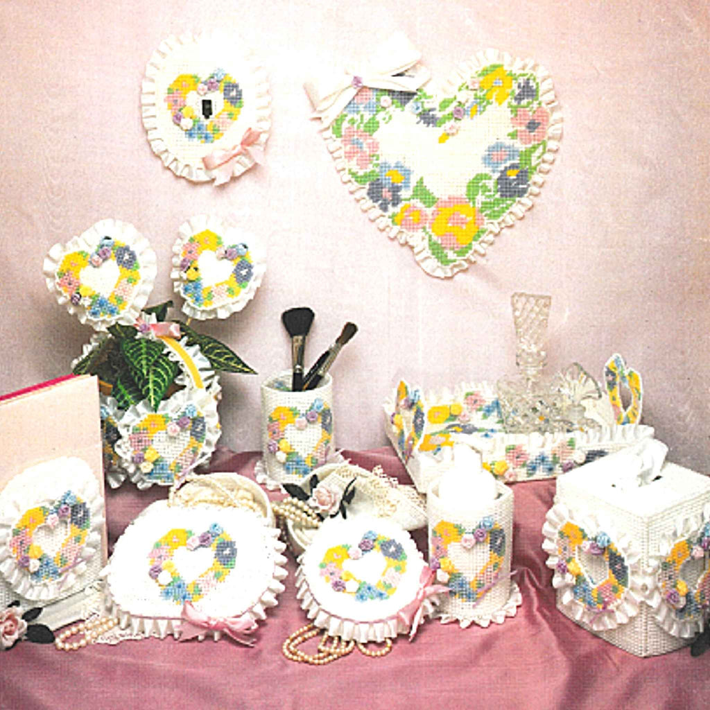 Vintage Plastic Canvas Pattern: A Pastel Bouquet. Charts included for cups, tray, tissue box cover, bookend, basket, jewelry box, small box, wall hanging, heart figures (plant pokes), and switchplate cover.