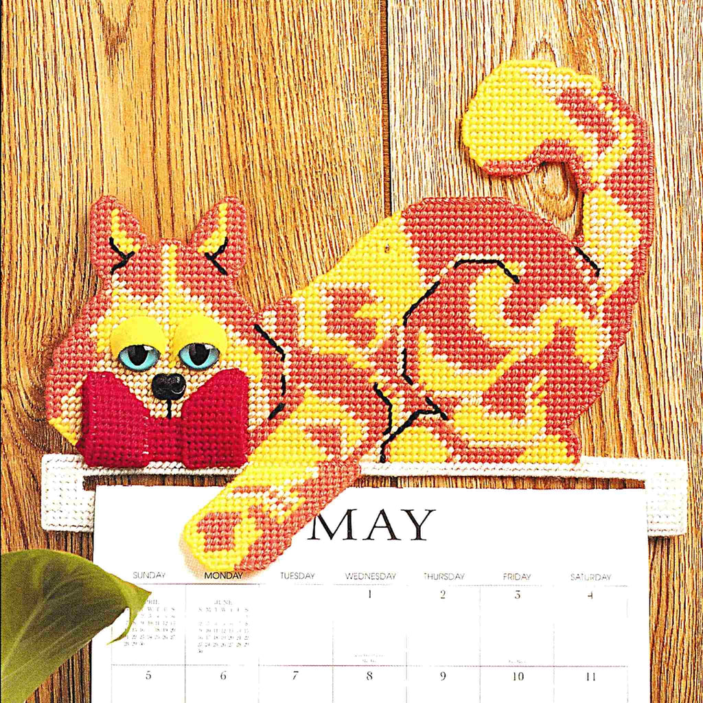 Vintage Plastic Canvas Pattern: Calendar Topper. Create a cute kitty cat calendar topper out of 7-count plastic canvas sheets and worsted / medium-weight yarn.